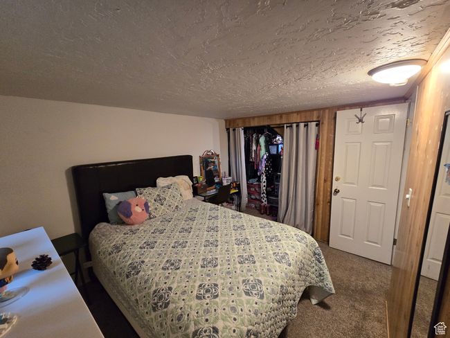Carpeted bedroom with a textured ceiling | Image 37