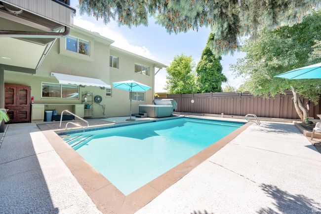 View of swimming pool featuring a patio area and a fenced backyard | Image 37