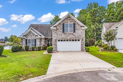 View of property featuring a garage and a front yard | Image 1