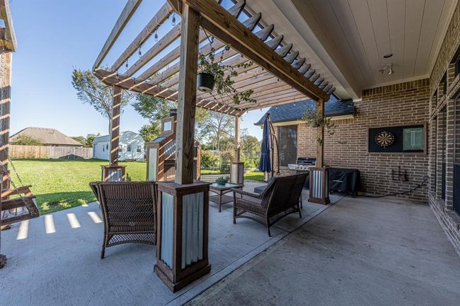 Enjoy stunning sunrises and peaceful sunsets. Extended back patio with custom Pergola, built-in swing and wood burning fireplace | Image 35