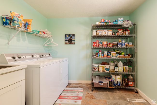 Laundry room featuring stone finish flooring, separate washer and dryer, baseboards, and laundry area | Image 11