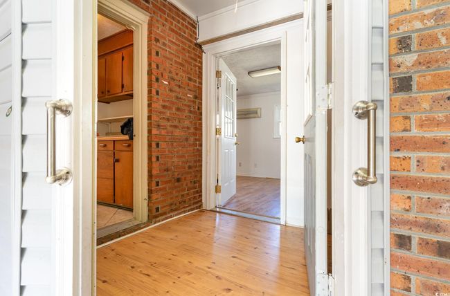 Hall featuring light hardwood / wood-style floors and brick wall | Image 22