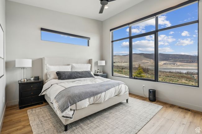 Bedroom with light wood-style floors, visible vents, and baseboards | Image 33