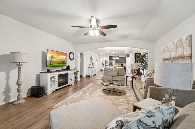 Living area with arched walkways, ceiling fan, and wood finished floors | Image 8