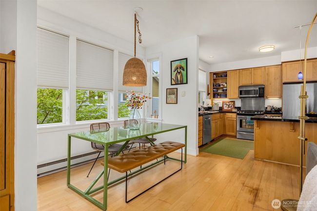 View to the dining nook and kitchen. The room has a western exposure and is bathed in natural light. | Image 8