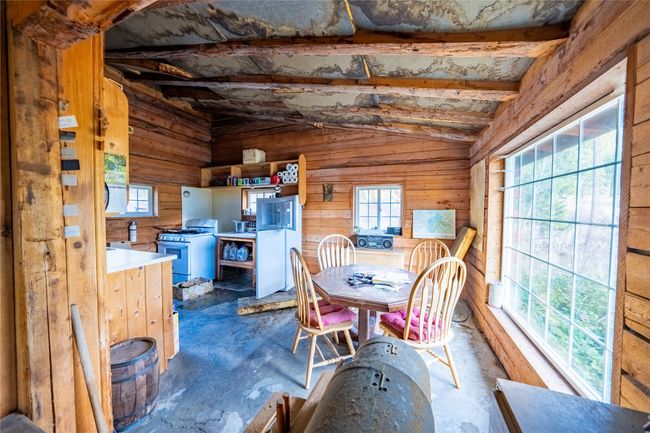 Dining room with wood walls, a healthy amount of sunlight, and vaulted ceiling with beams | Image 24