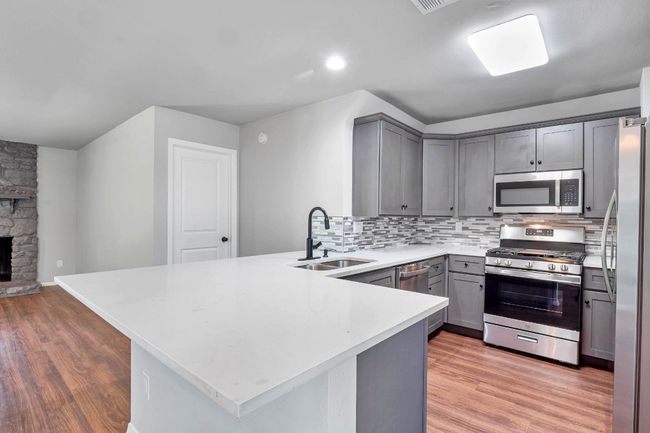 Swanky kitchen with Quartz, Custom painted cabinets, glass backsplash | Image 5