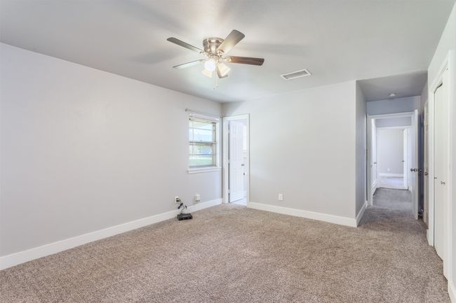 Unfurnished bedroom featuring carpet floors, visible vents, a ceiling fan, and baseboards | Image 20