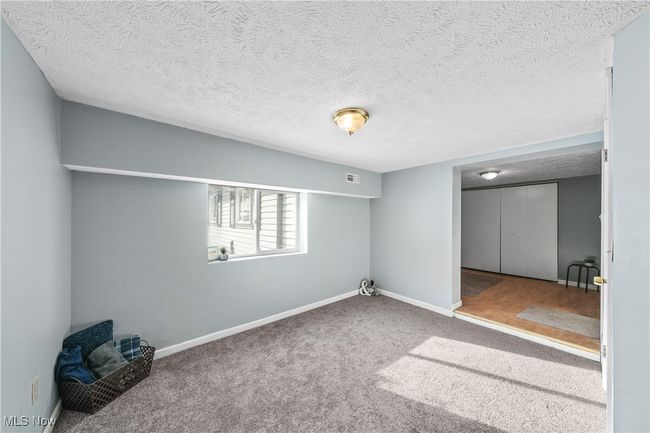 Basement room with light carpet and a textured ceiling | Image 21