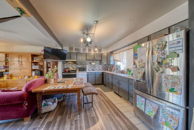 Kitchen featuring light countertops, backsplash, appliances with stainless steel finishes, gray cabinetry, and under cabinet range hood | Image 8