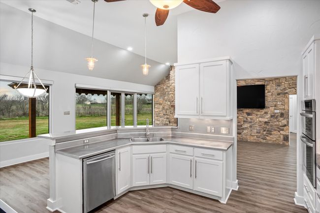 Kitchen with white cabinets, decorative light fixtures, dishwasher, and sink | Image 29