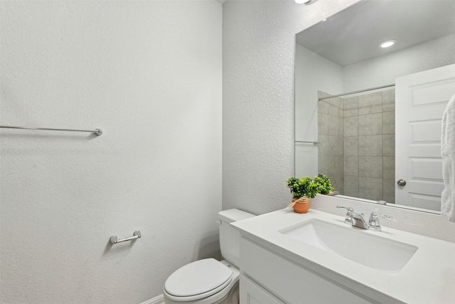 Bathroom with vanity, a textured wall, and a shower | Image 19