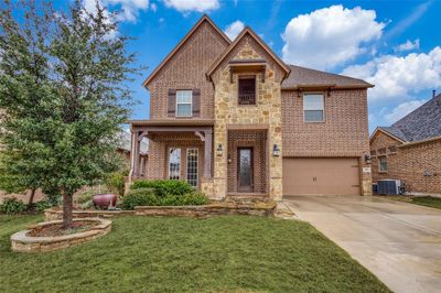 View of front of home featuring cooling unit, a garage, and a front yard | Image 1