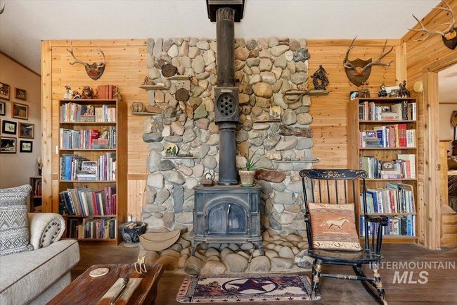 Living room featuring a wood stove, wood walls, and wood finished floors | Image 15