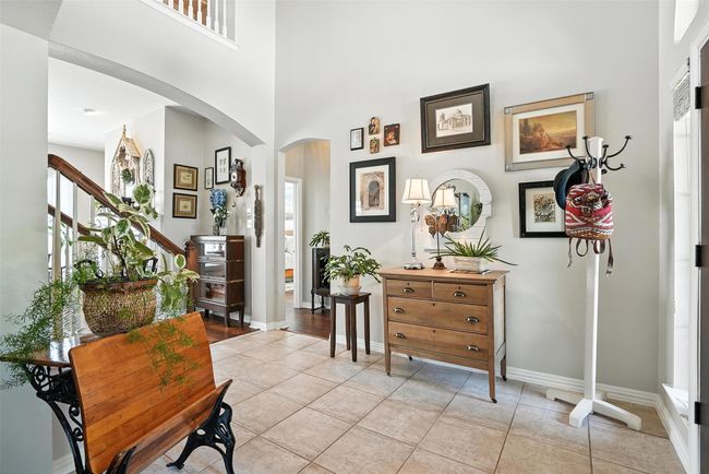 Entryway with arched walkways, light tile patterned flooring, a high ceiling, and stairs | Image 4