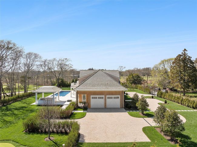 View of front of home featuring roof with wood shingles, attached garage, and driveway | Image 47