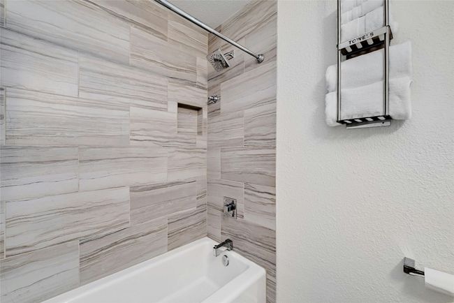 This full bathroom includes a bathtub/shower combo. | Image 26