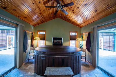 Tiled office space with plenty of natural light, ceiling fan, and wood ceiling | Image 2