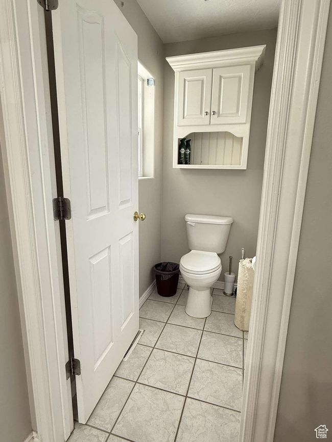 Bathroom with toilet, tile patterned floors, and baseboards | Image 37