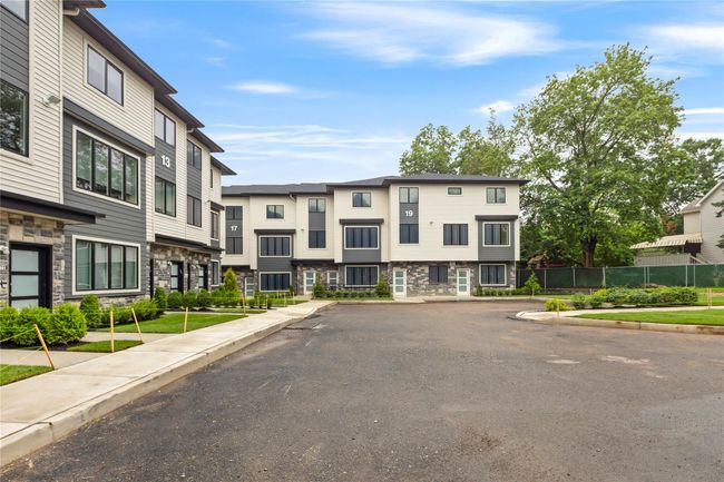 View of asphalt road featuring sidewalks, curbs, and a residential view | Image 6