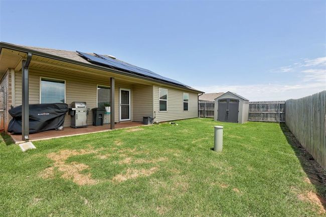 Fenced backyard with a storage unit and a patio area | Image 40