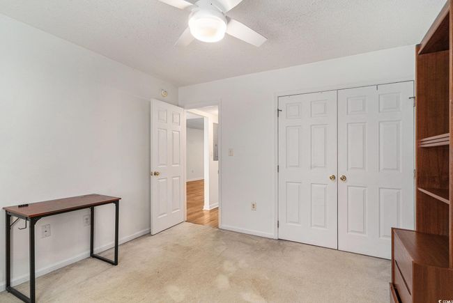 Unfurnished bedroom featuring light carpet, baseboards, a closet, and ceiling fan | Image 7