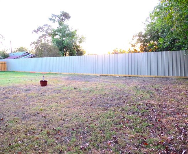 Enjoy enhanced privacy with a newly installed, durable metal fence surrounding a spacious backyard. | Image 46