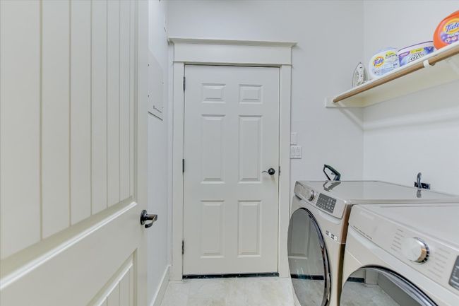 Laundry area with washer and dryer and baseboards. Door leading to the garage. | Image 11
