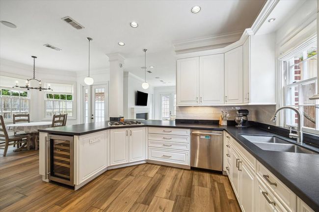 Kitchen overlooks breakfast area and den. Lots of storage. Built in beverage fridge for extra cold storage. Dual stainless steal sink. | Image 11
