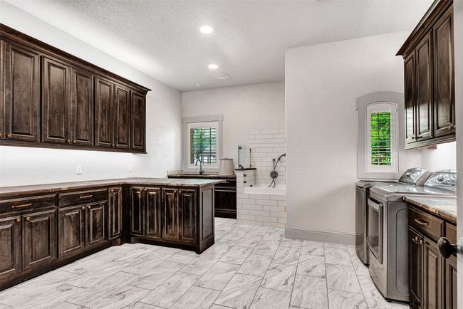 The utility room just might sell the house! Huge, spacious and sunny, it offers tons of counter and cabinet space, dog shower and sink, room for a freezer and so much more. | Image 28