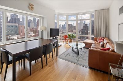 Living room with plenty of natural light and light hardwood / wood-style floors | Image 1