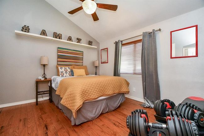A warm, high ceiling and wood? laminate? wood-look tile? flooring makes this secondary bedroom a great place for both family and visiting guests. Any, secondary, for that matter, may also serve as a nursery, home office, work out room? It's all up to you. | Image 34