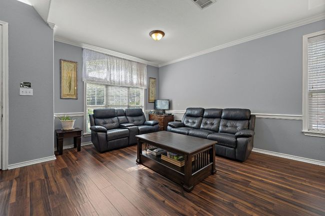 Living area with crown molding, and wood finished floors. | Image 4