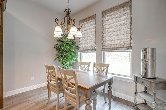 Dining room with a chandelier and light wood finished floors | Image 17
