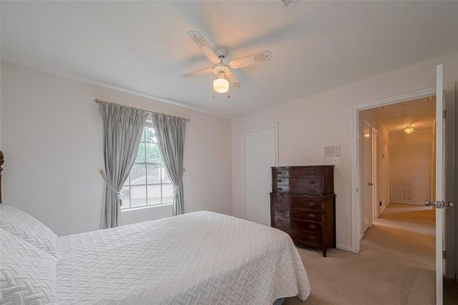 Cozy and inviting second bedroom featuring soft natural light, a charming ceiling fan, and ample space for comfort and relaxation. | Image 23