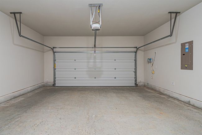 Garage featuring electric panel and a garage door opener | Image 11