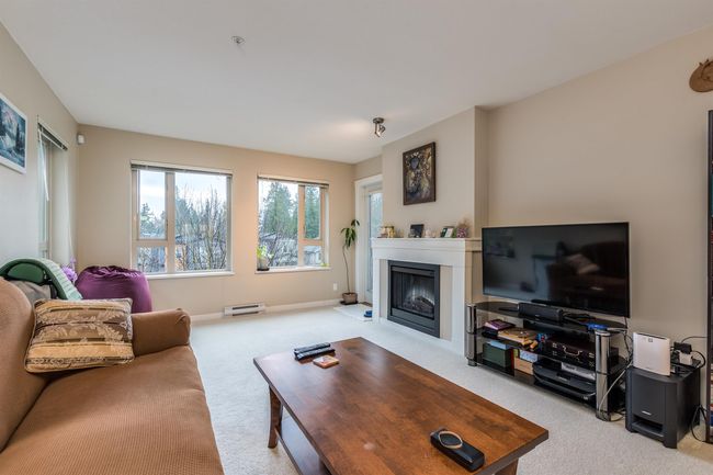 Carpeted living area with a fireplace with flush hearth and baseboards | Image 10