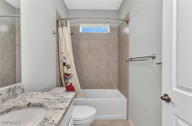 Full bathroom featuring toilet, shower / bath combo, vanity, and tile patterned flooring | Image 32