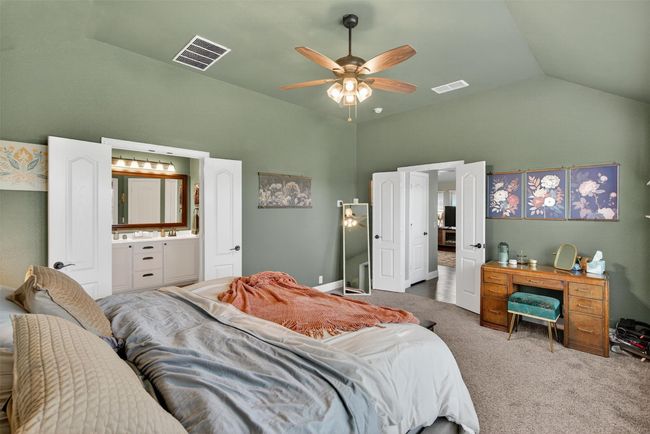 Bedroom featuring carpet, ceiling fan, high vaulted ceiling, and ensuite bath | Image 25