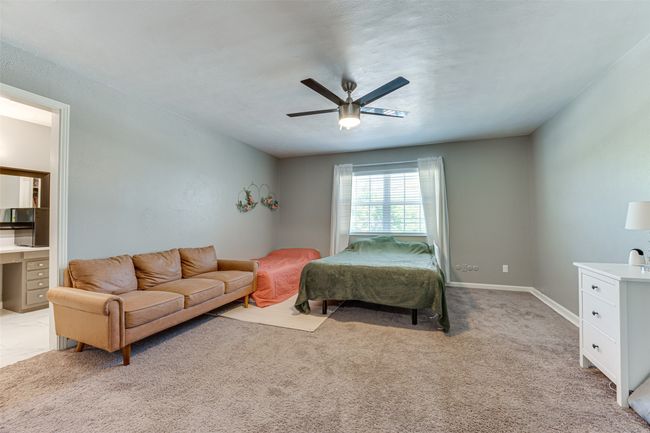 Bedroom featuring light carpet, ceiling fan, and baseboards | Image 13