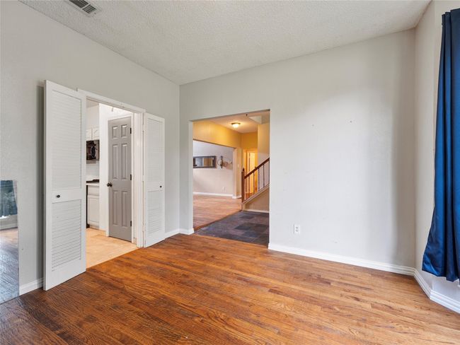 Unfurnished room with light wood-style floors, stairs, and a textured ceiling | Image 8