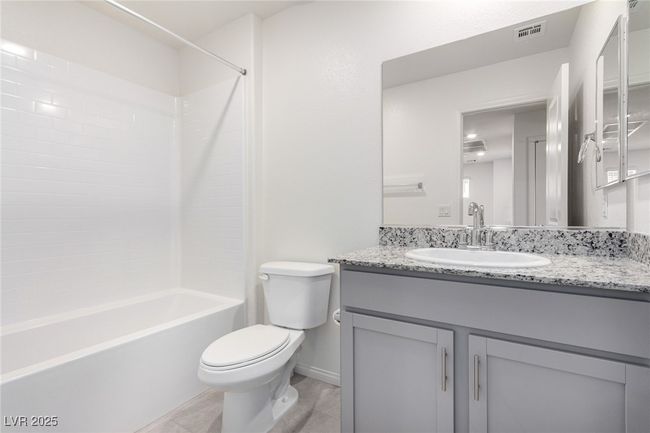 Bathroom with visible vents, baseboards, toilet, shower combination, and vanity | Image 21