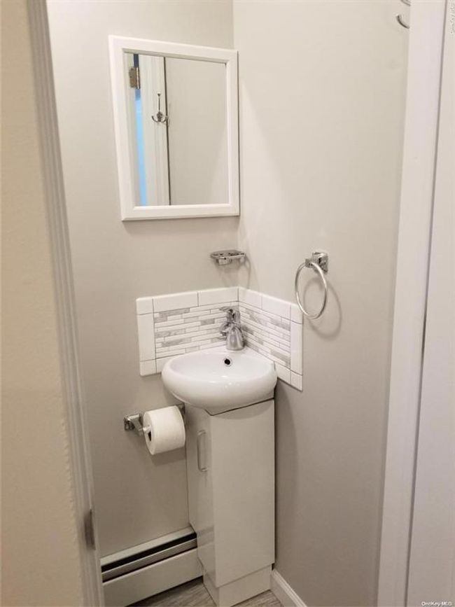 Bathroom featuring a baseboard radiator and baseboards | Image 14