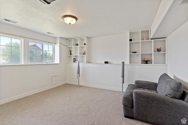 Living area with carpet, a textured ceiling, and baseboards | Image 19