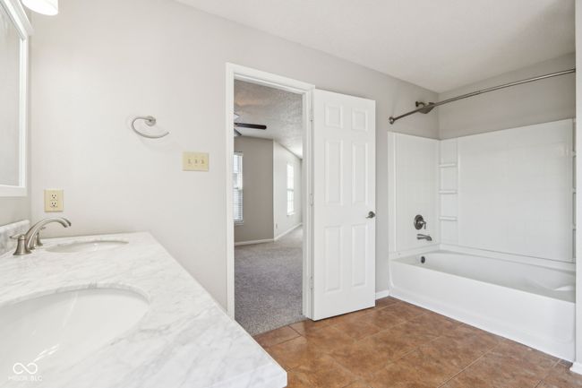 bathroom with tub / shower combination, double vanity, tile patterned floors, and ceiling fan | Image 43