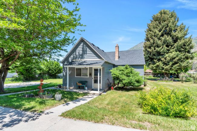 Bungalow-style home featuring a chimney, roof with shingles, and covered porch | Image 21
