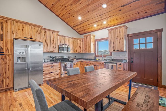 Kitchen with high vaulted ceiling, recessed lighting, stainless steel appliances, wood ceiling, and light wood finished floors | Image 11