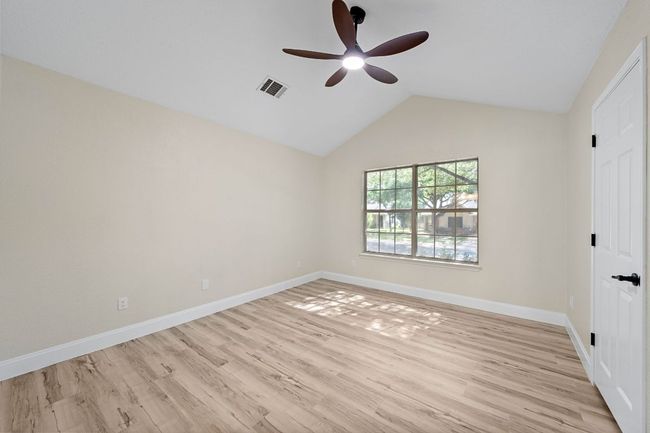 Unfurnished bedroom with light wood finished floors, lofted ceiling, and a ceiling fan | Image 27