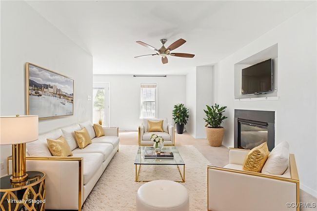 Living area featuring a glass covered fireplace, a ceiling fan, and carpet | Image 12