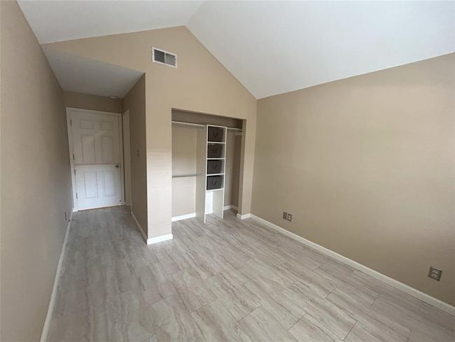 The primary closet with lots of hanging and shelf space and the en suite bath is at the front on the right. | Image 36
